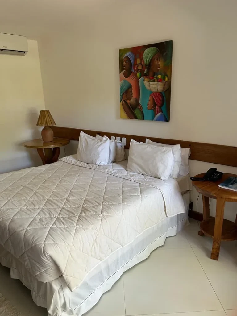 Suíte Executiva — Cama e espelho do quarto