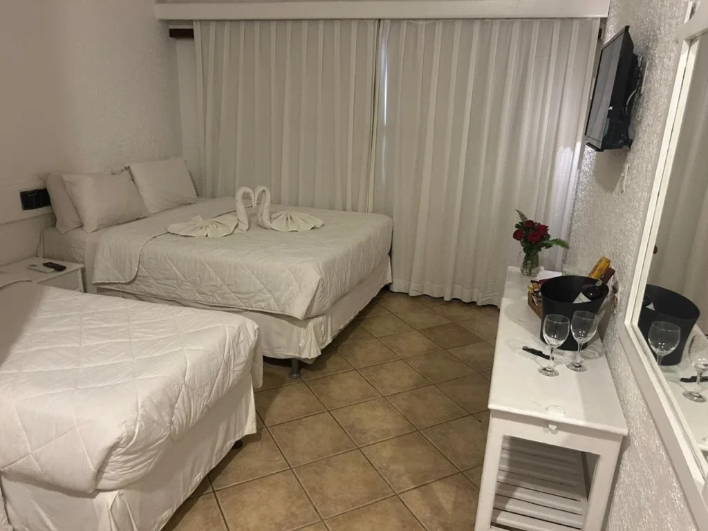 Suíte Vista Piscina Térreo — Quarto com duas camas e televisão
