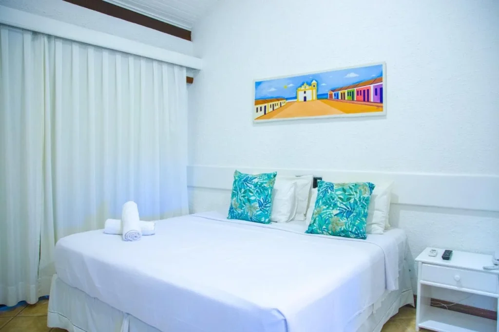 Suíte Vista Piscina Térreo — Cama de casal e almofadas azuis