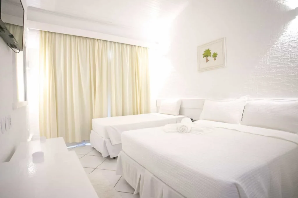Suíte Vista Piscina Térreo — Quarto com cortinas e duas camas